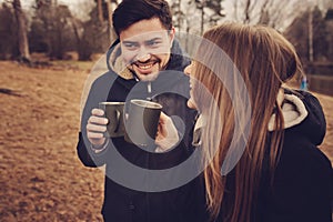 Loving young couple happy together outdoor, drinking tea from thermos, autumn camp