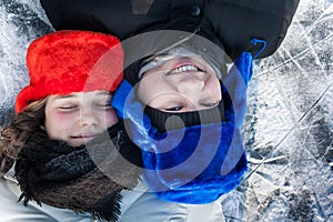 Loving young couple having fun on snow with ice background during Christmas holidays