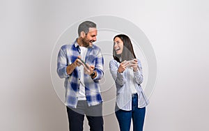 Loving young couple looking at each other and laughing ecstatically while playing video game against background. Cheerful