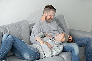 Loving young couple relaxing on couch enjoying weekend at home