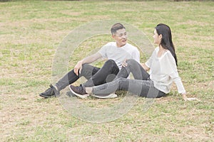 Loving young couple sitting down on grass