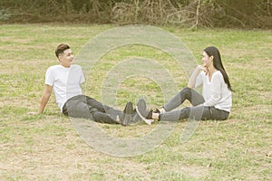 Loving young couple sitting down on grass