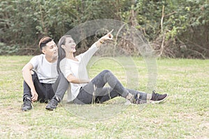 Loving young couple sitting down on grass