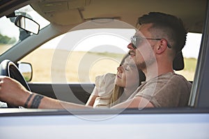 Loving young couple traveling by car