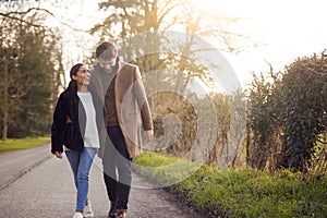 Loving Young Couple Walking Through Winter Countryside Together