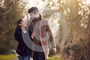 Loving Young Couple Walking Through Winter Countryside Together