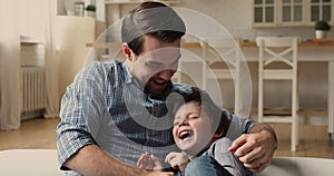 Loving young father play with little son at home