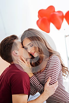 Loving young man kissing his girlfriend