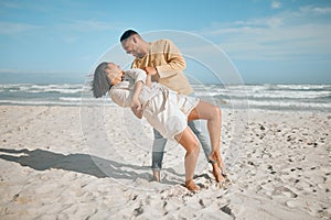 Loving young mixed race couple dancing on the beach. Happy young man and woman in love enjoying romantic moment while on