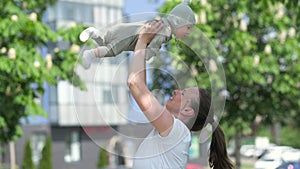 Loving young mom kisses little infant child, Mother And Baby Kissing, Happy Cheerful Family in summer park outdoor.