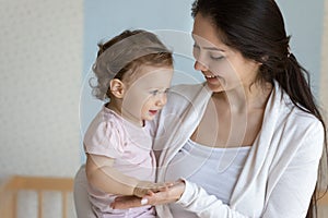 Loving young mom play with newborn baby daughter