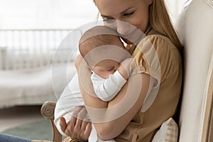 Loving young mother caress newborn baby infant