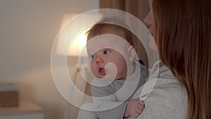 Loving Young Mother Holding Cute Newborn Baby On Hands And Smiling