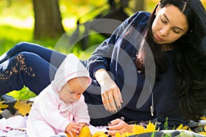 Loving young mother watching her baby daughter.