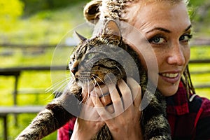 Loving young woman cuddling her cat to her cheek