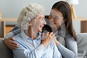 Loving young woman granddaughter hugging senior grandma giving care