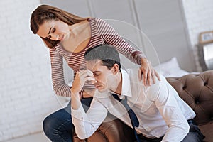 Loving young woman helping her depressed husband