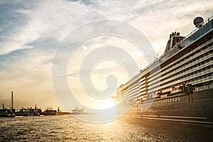 Low angel view of large cruise ship leaving harbor at sunset