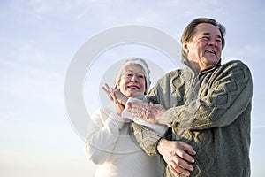 Low angle of affectionate mature couple arm in arm