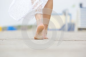 Low angle barefoot woman walking away