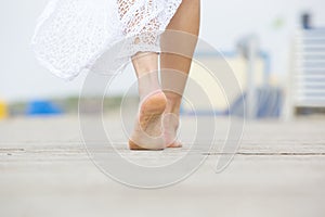 Low angle barefoot woman walking away photo