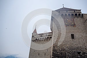 Low angle of beautiful clock tower in chateau de chillon, castle in Montreux Switzerland, on cloudy sky background