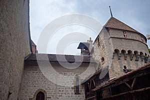 Low angle of beautiful tower in chateau de chillon, castle in Montreux Switzerland, on cloudy sky background