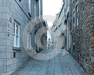 Low angle blue hour morning view of narrow street lined with mid-eighteenth Century stone houses