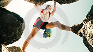 Low angle close up one young caucasian sporty woman alone train rock climb outdoors in sunny hot weather alone. Inspirational