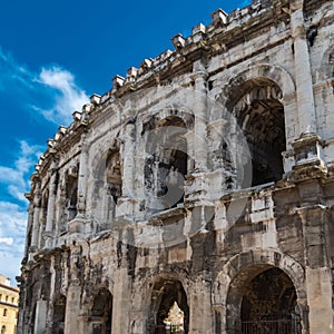 Low-angle closeup of Amphitheatre of Nimes against sunlit, clear sky background