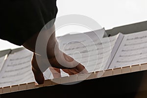 Low angle closeup shot of person hands of a piano player on the piano keyboard