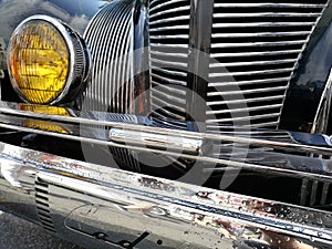 Low angle closeup view of the headlights of an old vintage car