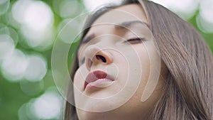 Low angle closeup woman with closed eyes meditates outdoors in slow motion, joy