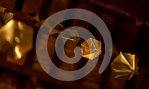 Low angle detail of a golden diamond hanging from the wooden ceiling of the granollers