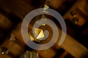 Low angle detail of a golden diamond hanging from the wooden ceiling of the granollers porch