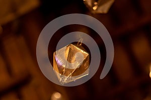 Low angle detail of a golden diamond hanging from the wooden ceiling of the granollers porch