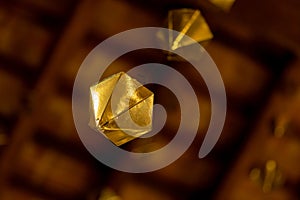 Low angle detail of a golden diamond hanging from the wooden ceiling of the granollers porch