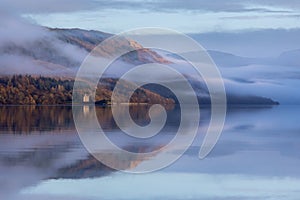 Low-angle of Dunderave castle on the foogy shores of the picturesque Loch Fyne, Scotland photo