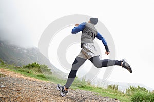 Low angle, fitness and man running in nature training, cardio exercise or endurance workout for wellness. Sports, runner