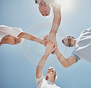 Low angle, friends and family with hands together, sunlight and support outdoor, bonding and team building. Teamwork