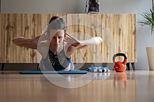 Low angle fron view of a young woman lying on a mat working out doing a back lift exercise