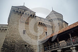 Low angle of front tower in chateau de chillon on cloudy sky background