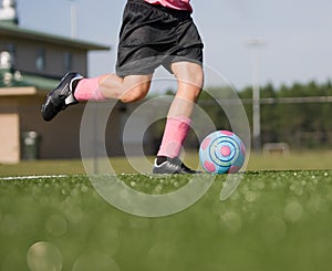 Low angle of girl kicking soccer ball