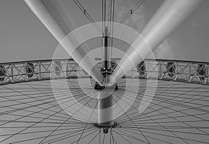 Low angle grayscale shot of rotating Ferris wheel details