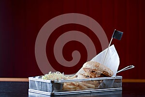 Low angle hamburger with beef burger cutlet, fried onion, ketchup sauce and french fries in traditional buns