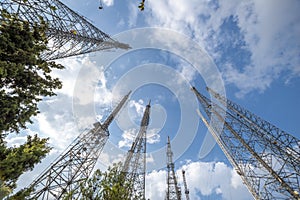 Low angle image of metallic communication towers with blue sky