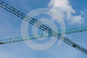 Low angle of jib cranes under a clear sky background