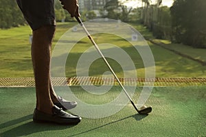 Low angle of man golfing at driving range