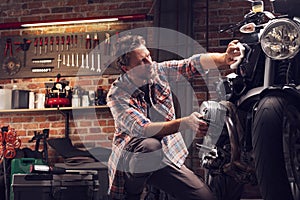 Man polish motorcycle in garage photo