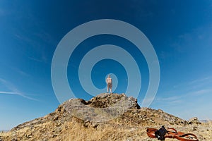Low angle of a man standing on top of the castle of Melhor, Portugal against a blue sky photo